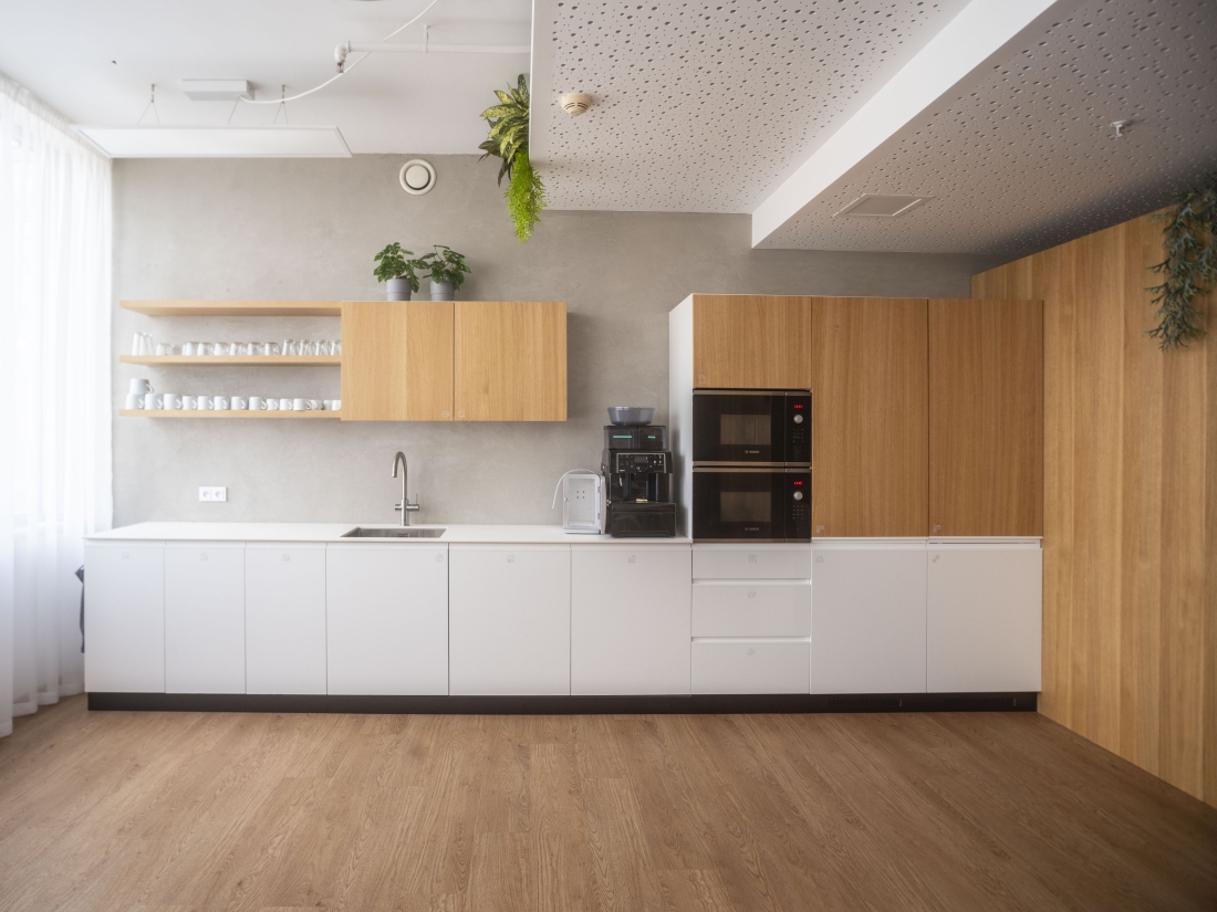 Firemní kuchyňské zázemí navazující materiálově na kancelářský interiér