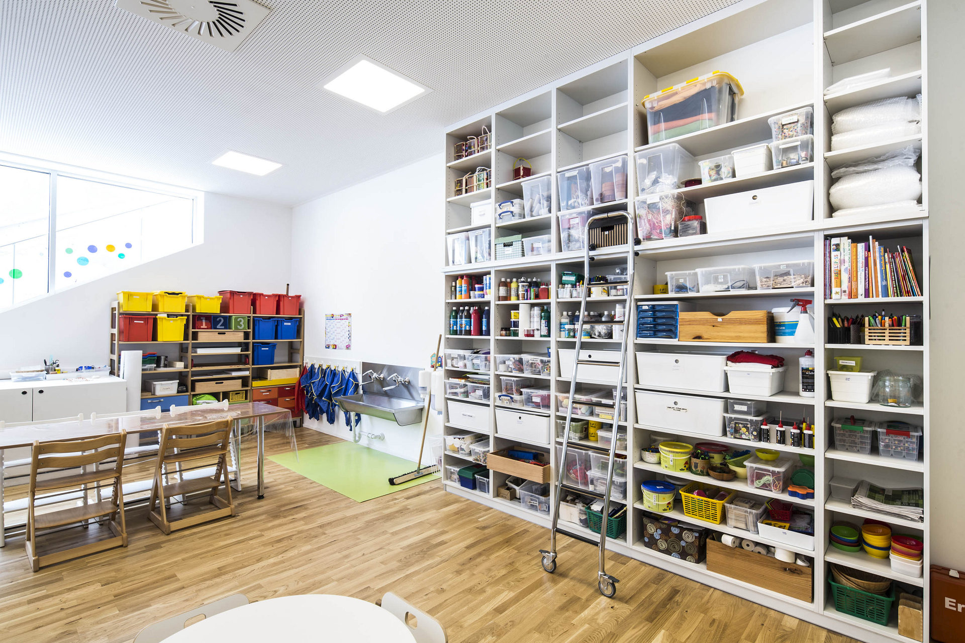 Školní úložné systémy s regály a plastovými kontejnery v učebně